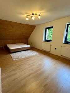 an empty room with a bed and two windows at Chalupa Bohunka in Kašperské Hory