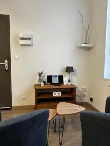 un soggiorno con un tavolo e una scrivania con un forno a microonde di Studio confortable pour 2 personnes a Saint-Omer