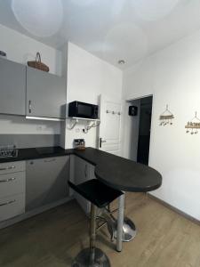 una cucina con tavolo nero in una stanza di Studio confortable pour 2 personnes a Saint-Omer