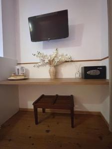 a shelf with a tv and a vase of flowers at Nali Room in La Vespière