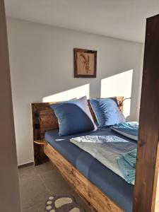 ein Schlafzimmer mit einem Holzbett mit blauen Kissen in der Unterkunft Spatz am Joch Zeit für Berge in Bad Hindelang
