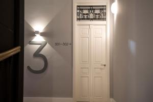 a white door with a light next to it at B&B HOTEL Apartamentos Madrid Centro Fuencarral 46 in Madrid