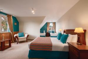 een hotelkamer met een groot bed en een stoel bij Park Inn by Radisson Puerto Varas in Puerto Varas +33 foto's