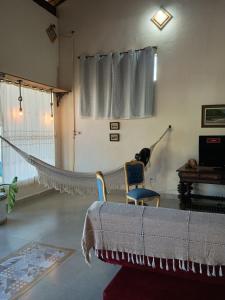 a hammock in a living room with a chair at Canto do Atlântico in Ilha Comprida