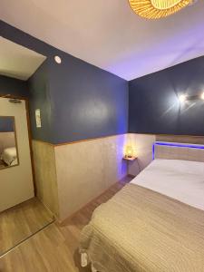 a bedroom with a bed and a blue wall at Nali Room in La Vespière