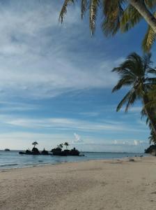 a beach with two palm trees and the ocean at RenSea Haven Boracay Rm10 in Boracay