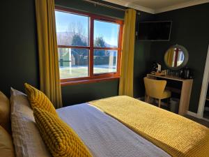 a bedroom with a bed and a window and a desk at Mizpah Bed & Breakfast near Ben Nevis Highlands in Roybridge