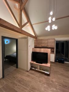 ein Wohnzimmer mit einem Flachbild-TV und ein Schlafzimmer in der Unterkunft Le chalet O'Perché - Wissembourg in Wissembourg + 13 Fotos