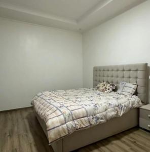 une chambre avec un grand lit dans une pièce blanche dans l'établissement Peace Haven Apartment, 