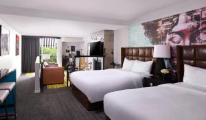 ein Hotelzimmer mit zwei Betten und einem Fernseher in der Unterkunft Montrose at Beverly Hills in Los Angeles + 30 Fotos