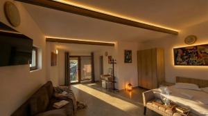 ein Wohnzimmer mit einem Bett und einer Couch in der Unterkunft Casa de sub Brazi Relaxare la munte cu Ciubar in Fîntînele
