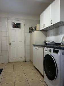 a kitchen with a washing machine and a white door at Casa en Pingueral para 7 personas in Dichato +12 photos