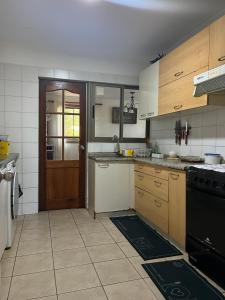 a kitchen with wooden cabinets and a black stove at Casa en Pingueral para 7 personas in Dichato