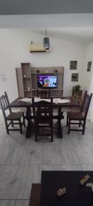 a living room with a table and chairs and a television at La Casita de Lucía in Almafuerte