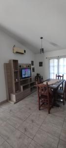 a living room with a table and chairs and a tv at La Casita de Lucía in Almafuerte
