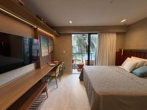 ein Schlafzimmer mit einem Bett und einem großen TV in der Unterkunft Garden Haus Beira-Mar, Jardim Oceania-Miramar Hospedagens in Tambaú + 231 Fotos