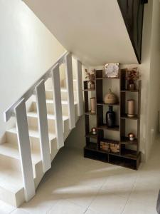 una scala bianca con scaffali in una stanza di Golden House a Tijuana