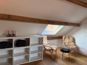 ein Zimmer mit weißen Regalen, zwei Stühlen und einem Dachfenster in der Unterkunft BeMe in Waterloo