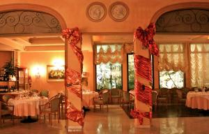 a dining room with tables and red bows at Phi Hotel Dei Medaglioni in Correggio