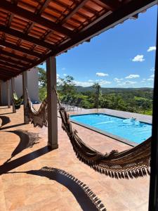 a hammock on a patio next to a swimming pool at Rancho Bela Vista in Alexânia