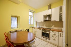 a kitchen with a wooden table and a wooden table and a table and chairs at Quattro Cantoni Apartment in Zadar