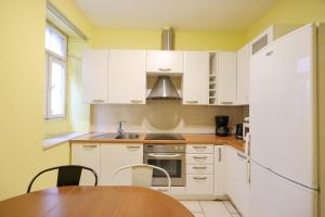 a kitchen with white cabinets and a wooden table at Quattro Cantoni Apartment in Zadar +29 photos