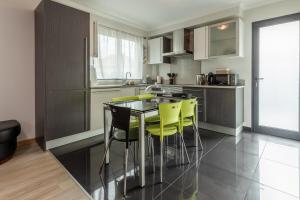eine Küche mit einem Tisch und gelben Stühlen in der Unterkunft Apartamento Ruby in Machico