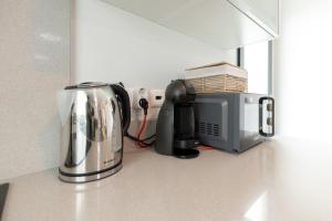 eine Küchenarbeitsplatte mit Toaster und Mikrowelle in der Unterkunft Apartamento Ruby in Machico