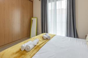 ein Schlafzimmer mit einem Bett, auf dem Handtücher liegen in der Unterkunft Apartamento Ruby in Machico