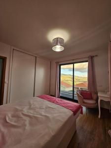 a bedroom with a large bed and a window at Villa Barros in Câmara de Lobos +57 photos