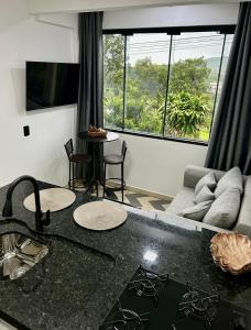 a living room with a couch and a table at Apto 01 casal praia e vista montanhas in Governador Celso Ramos