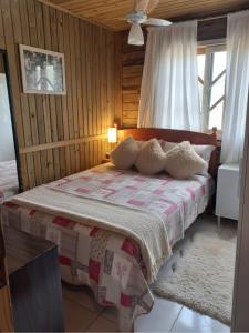 een slaapkamer met een bed met een dekbed erop bij Casa Rústica em Garopaba in Garopaba