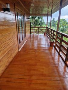 een lege veranda van een huis met houten vloer en ramen bij Ké San Gélica in São Tomé