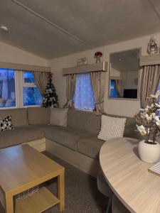a living room with a couch and a table at Wilson Getaways - Caravan Hire in Rhyl