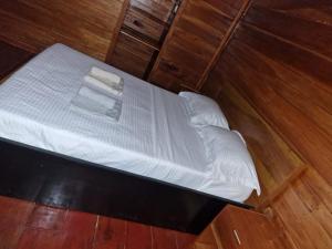 een bed met witte lakens en kussens bij Ké San Gélica in São Tomé