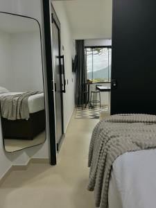 a bedroom with two beds and a view of a table at Apto 01 casal praia e vista montanhas in Governador Celso Ramos