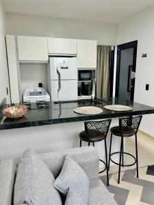 a living room with a couch and a kitchen with a counter at Apto 01 casal praia e vista montanhas in Governador Celso Ramos +13 photos