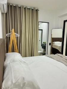 a bedroom with a white bed and a mirror at Apto 01 casal praia e vista montanhas in Governador Celso Ramos