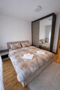 een groot bed in een kamer met een grote spiegel bij Royal Queen in Vrnjačka Banja