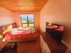 una camera da letto con un letto e una TV a schermo piatto di La puntilla a Compu