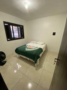 a bedroom with a bed in a room with a window at Casa para Pernoite no Centro de Osório in Osório