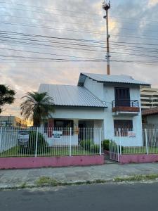 a white house with a fence in front of it at Casa para Pernoite no Centro de Osório in Osório