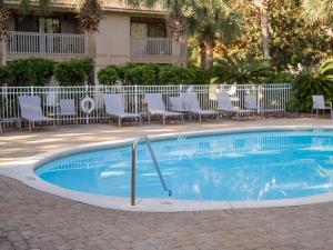 a small swimming pool with chairs and a building at Sweet Bay on 30A in Seagrove Beach