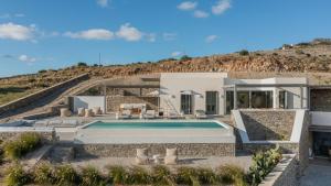 een huis met een zwembad voor een heuvel bij Avera Villas in Parikia