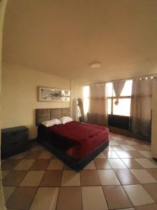 een slaapkamer met een rood bed en een raam bij Entire Space in Downtown Oaxaca Comfortable in Oaxaca City