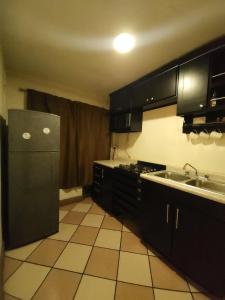 een keuken met een zwarte koelkast en een spoelbak bij Entire Space in Downtown Oaxaca Comfortable in Oaxaca City