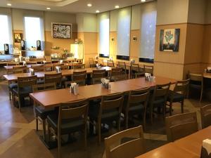 a dining room with wooden tables and chairs at Hotel Route-Inn Tosu Ekimae in Tosu