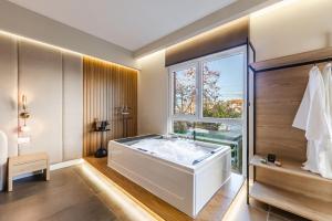 a bathroom with a large white tub and a window at Zoe's Villa by PS in Durrës +93 photos