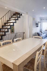 a dining room with a white table and a staircase at Casa Bordoli in Cortona +25 photos