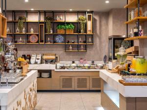 een keuken met veel gerechten op de planken bij Novotel Istanbul Zeytinburnu in Istanbul
